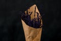 Close up view of delicate fragnant lavender flowers bouquet wrapped in paper on dark background