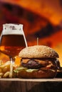 close-up view of delicious beef burger with french fries and glass of beer Royalty Free Stock Photo
