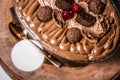 chocolate frosted dessert sitting on top of a wooden platter with spoons and