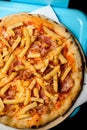 close-up view on delicious italian pizza with topping of french fries and bacon slices. Royalty Free Stock Photo