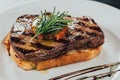 close-up view of delicious juicy beef steak with rosemary and roasted bread