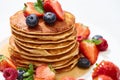 Close up view of delicious pancakes with honey, blueberries and strawberries on plate on white surface Royalty Free Stock Photo