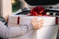 Close-up view of delivery man standing near car preparing to take parcel out of trunk of car. Royalty Free Stock Photo