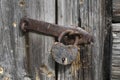 Old rusty padlock on a aged gray wooden door Royalty Free Stock Photo