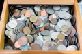 Close up view of different countries coins in a wooden box. Various metal coins background