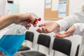 Close-up view of disinfecting hands of patients entering a clinic, performed by medical staff in the face of a pandemic Royalty Free Stock Photo