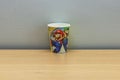 Close-up view of disposable paper cup with Mario theme.