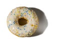 Close up view of donut sprinkled with multicolored glaze isolated on white background.