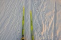 Close up view down yellow plastic Fischer skis rolling down ski track.