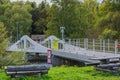 Close-up view of drawbridge over navigable river against backdrop of autumn forest. Royalty Free Stock Photo