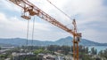 Close-up View From A Drone Of A Construction Crane Cabin Against The Backdrop Of Beautiful Sea, Sky And Mountain.