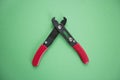 Close-up view of duckbill pliers over green background Royalty Free Stock Photo