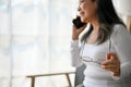 Close up view of elderly woman having a phone call while holding a glasses Royalty Free Stock Photo