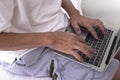 Close up view of eldery man hands using laptop computer on bed Royalty Free Stock Photo