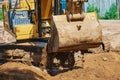 Close up view of an excavator bucket full of earth. The process of digging soil at a construction site. Selective focus