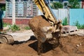 Close up view of an excavator bucket full of earth. The process of digging soil at a construction site. Window of an old Royalty Free Stock Photo