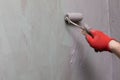 A close-up view of an experienced construction worker applying damp insulation using a paint roller on a wall