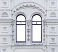 Facade of white ancient building with two-part isolated arched windows