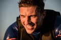 Close-up view of face of cheerful athletic man in wetsuit and vest