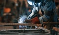 Close up view. Factory worker in protective mask is welding the iron