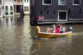 Close up view of a family riding a small, yellow, open boat