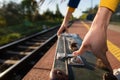 A girl fastens the zipper on an old travel suitcase on a train platform one summer afternoon during a planned train trip Royalty Free Stock Photo