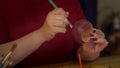 Close-up view of female artist coloring with paintbrush whooden jewelry bracelet