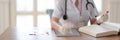 Close up view of female doctor holding test tube and looking for Information in a Medical Book Royalty Free Stock Photo