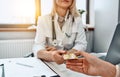 Close up view of female doctor`s hand giving pills in blister to female patient in clinic Royalty Free Stock Photo