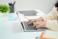 Close up view of female employee hands typing on laptop compute keyboard, searching online information working at office