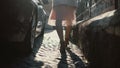 Close-up view of female feet walking through the urban street. Female in shoes and skirt going in the city centre. Royalty Free Stock Photo