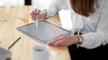 Close up view of freelancer drawing on mock up digital tablet on wooden desk