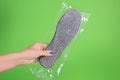 Female hand holding new just bought couple of insoles for winter footwear