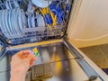 Close up view of female hand inserting dishwasher tablet Royalty Free Stock Photo