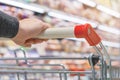 Close up view of a female hand with pushcart in supermarket Royalty Free Stock Photo