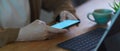 Female hands using mock up horizontal smartphone while working on table