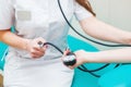 Close up view of female medicine doctor measuring blood pressure to her patient. Hands close up. Healthcare, healthy lifestyle and Royalty Free Stock Photo