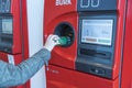 Close up view of female putting metal can to recycling automatic machine. Europe.