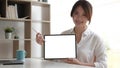 Close up view of female worker showing mock up tablet screen while standing in office room