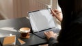 Close up view of female working on mock up digital tablet in comfortable workplace