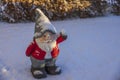 Close-up view of figure of Santa Claus gnome standing on snow in winter garden.