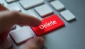 Close-up view finger poised on large red DELETE key. Action data removal. Digital interactions need decisive action. Urgent tech