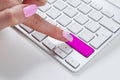 Close up view of a Finger Pushing on a pink empty Button on computer Keyboard. Finger Pressing a Slim Aluminium Keyboard Button. M