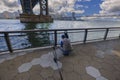 Close up view of fisherman under Brooklyn Bridge catching fish. New York.