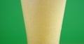 Close up view of a fizzing pint of beer for st patrick on green background