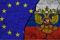 Close-up view of the flag of the European Union and the flag of the Russian Federation on a background of cracked earth. The Royalty Free Stock Photo