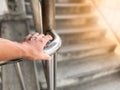 A hand of person reaching for iron railing.