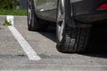 Close-up view flat rear tire on a car. Detail of car wheel flat tire on the road, parking lot. Burst tire background.