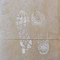 Close-up view of the footprints of shoes on a dirty asphalt. Adventure or travel concept. Space for text