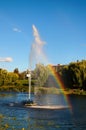 Close-up view of fountain with a beautiful rainbow. Blue sky background. A rainbow made in water fountain. Scenic autumn landscape Royalty Free Stock Photo